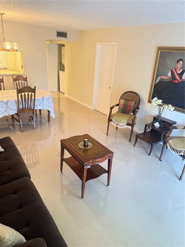 901 Colony Point Cir Unit 217, Pembroke Pines, FL 33026 - living room featuring an inviting chandelier, a textured ceiling, and visible vents