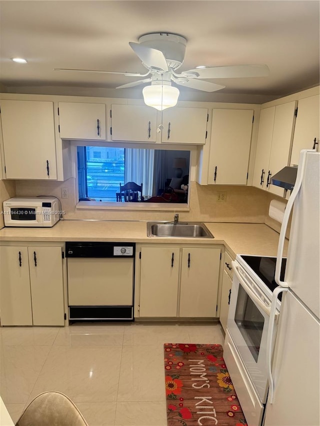kitchen featuring a ceiling fan, a sink, light countertops, under cabinet range hood, and white appliances