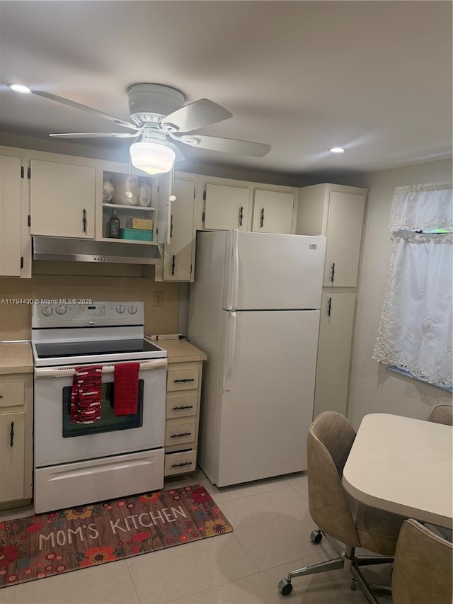 kitchen with white appliances, under cabinet range hood, light tile patterned floors, and light countertops