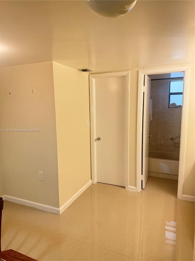 unfurnished bedroom with baseboards and light tile patterned floors