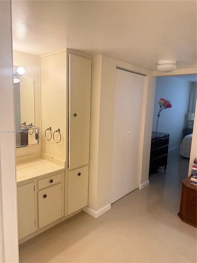 bathroom featuring vanity, baseboards, and tile patterned floors