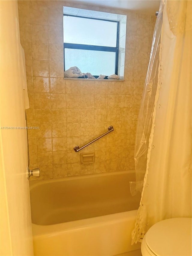 bathroom featuring toilet and shower / tub combo