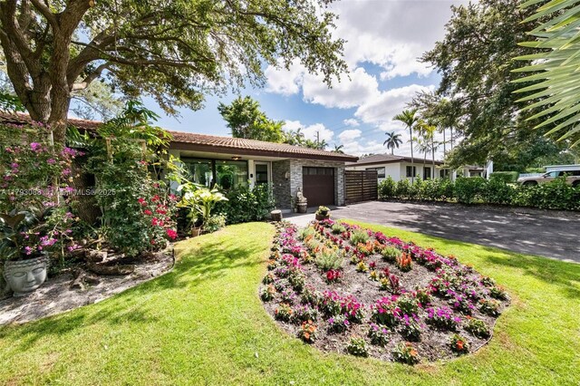 480 NW 88th Ter, El Portal, FL 33150 - view of front of home featuring a tile roof, driveway, an attached garage, and a front yard