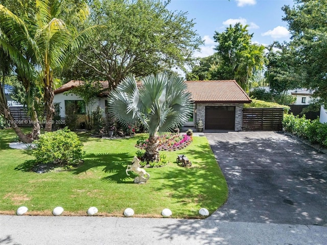 view of front of property with a garage, a front lawn, aphalt driveway, stone siding, and a tile roof