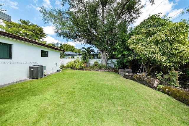 view of yard featuring central AC unit and a fenced backyard
