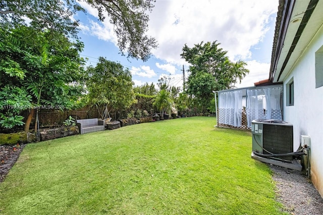 view of yard featuring fence and central AC unit