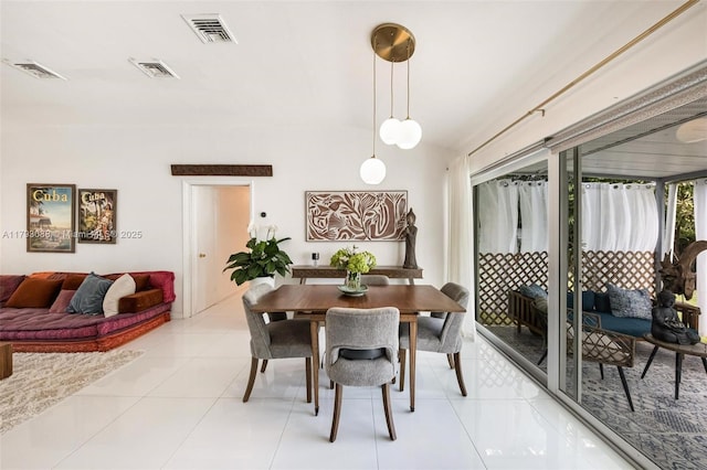 dining room featuring visible vents, lofted ceiling, and light tile patterned flooring