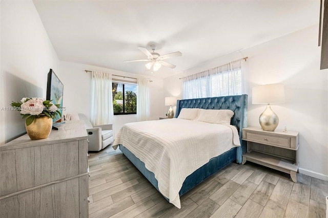 bedroom with baseboards, a ceiling fan, and light wood-type flooring