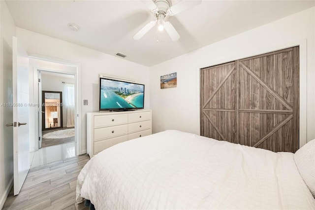 bedroom featuring light wood-style floors, baseboards, ceiling fan, and visible vents