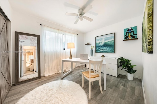 home office featuring baseboards, ceiling fan, and wood finished floors