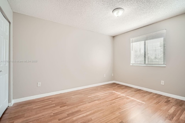 7451 SW 157th Ct, Miami, FL 33193 - empty room with a textured ceiling, baseboards, and light wood-type flooring