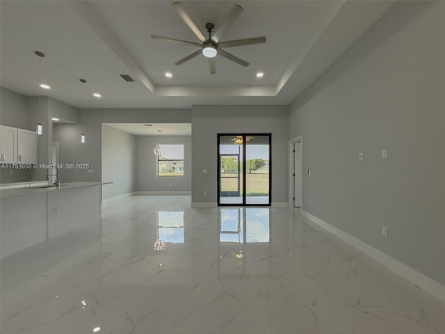 417 Paddock St, Lehigh Acres, FL 33974 - spare room featuring a ceiling fan, light marble finish flooring, baseboards, a tray ceiling, and recessed lighting