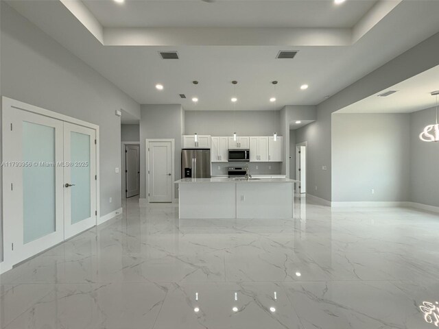 417 Paddock St, Lehigh Acres, FL 33974 - unfurnished living room featuring recessed lighting, baseboards, light marble finish floors, a raised ceiling, and a sink