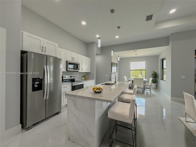 417 Paddock St, Lehigh Acres, FL 33974 - kitchen featuring appliances with stainless steel finishes, a sink, light marble finish flooring, white cabinets, and recessed lighting