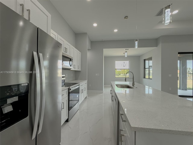 417 Paddock St, Lehigh Acres, FL 33974 - kitchen featuring stainless steel appliances, a sink, a large island with sink, light marble finish flooring, and recessed lighting