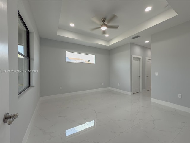 417 Paddock St, Lehigh Acres, FL 33974 - spare room featuring baseboards, recessed lighting, a ceiling fan, a tray ceiling, and light marble finish flooring