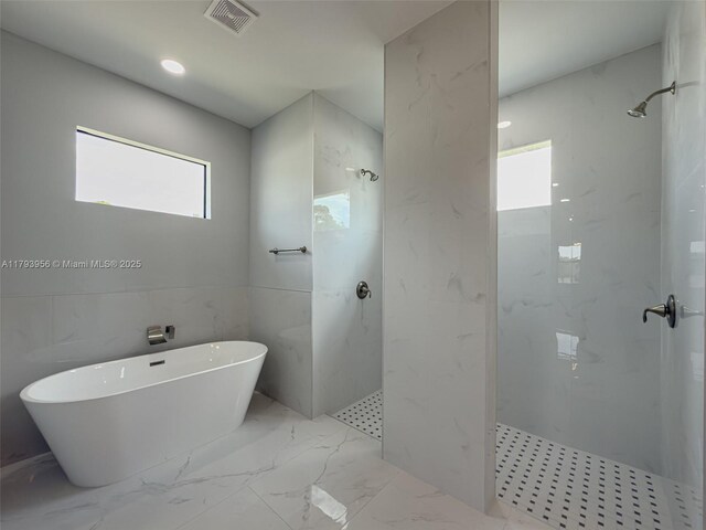417 Paddock St, Lehigh Acres, FL 33974 - bathroom featuring a marble finish shower, a soaking tub, and marble finish floors