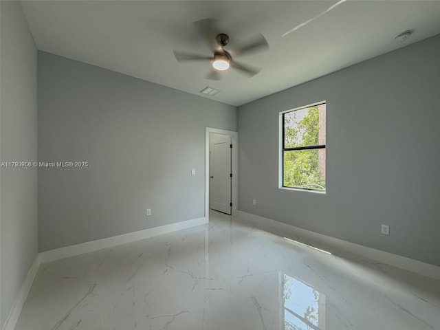 417 Paddock St, Lehigh Acres, FL 33974 - spare room featuring light marble finish flooring, baseboards, a ceiling fan, and a smoke detector