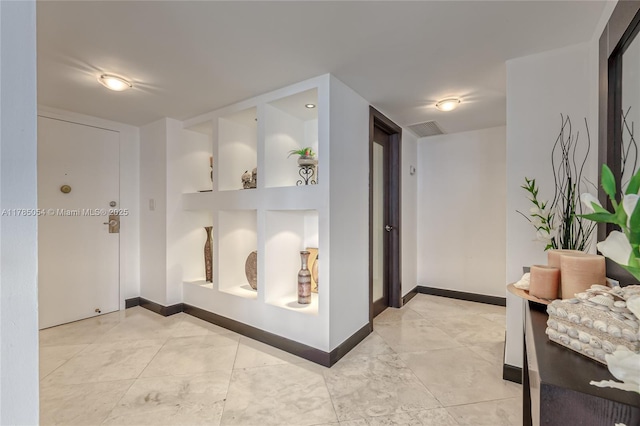 corridor with baseboards and visible vents