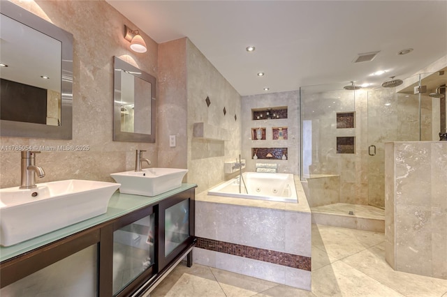 bathroom featuring a jetted tub, a sink, a stall shower, and tile patterned flooring