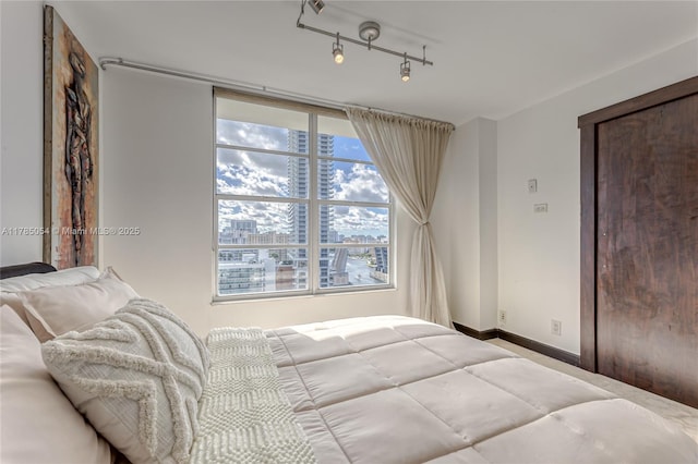 bedroom featuring a view of city and baseboards