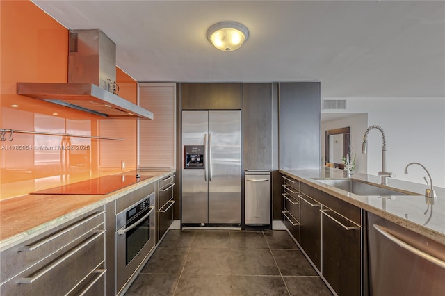 kitchen with visible vents, island range hood, dark tile patterned floors, a sink, and appliances with stainless steel finishes