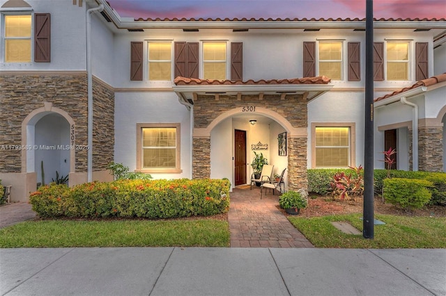 view of front of house with stucco siding and stone siding