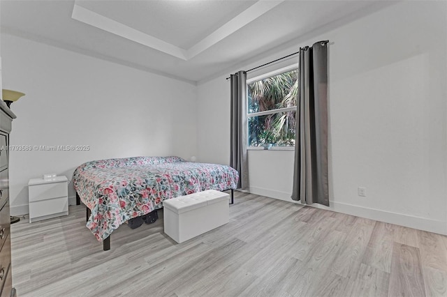 5301 Ellery Ter, West Palm Beach, FL 33417 - bedroom featuring baseboards, a raised ceiling, and light wood-style flooring