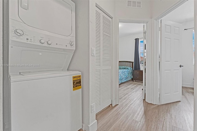 5301 Ellery Ter, West Palm Beach, FL 33417 - clothes washing area featuring stacked washer / drying machine, visible vents, and light wood finished floors