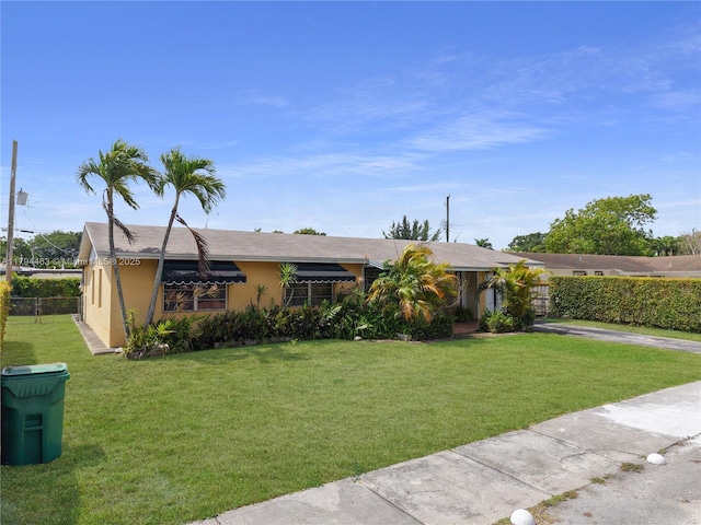 single story home with stucco siding, driveway, a front yard, and fence