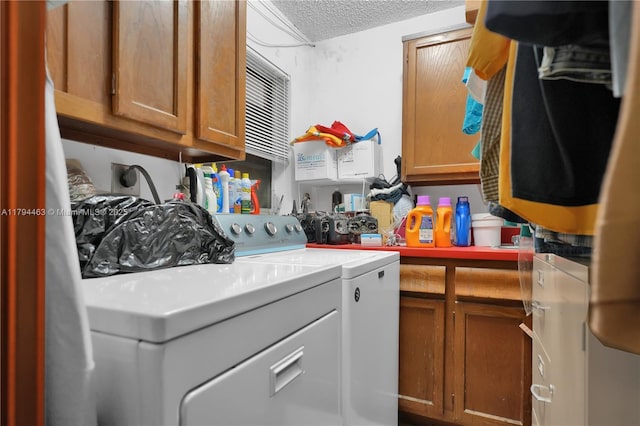 washroom featuring cabinet space, separate washer and dryer, and a textured ceiling