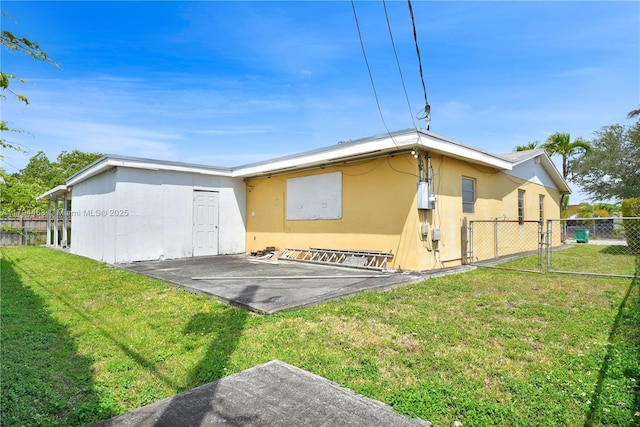 back of house featuring a yard, fence, a patio area, and stucco siding