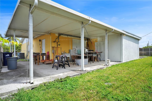 rear view of property with a yard, a patio, and central AC