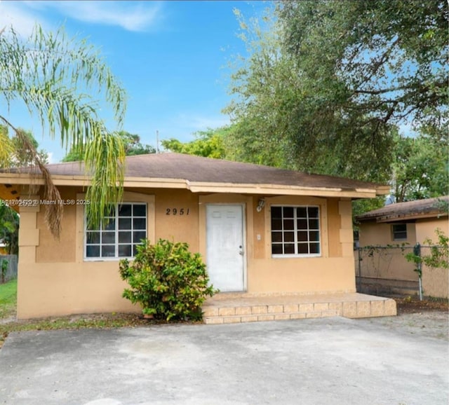 2951 NW 57th St, Miami, FL 33142 - view of front of home featuring fence, a patio area, and stucco siding