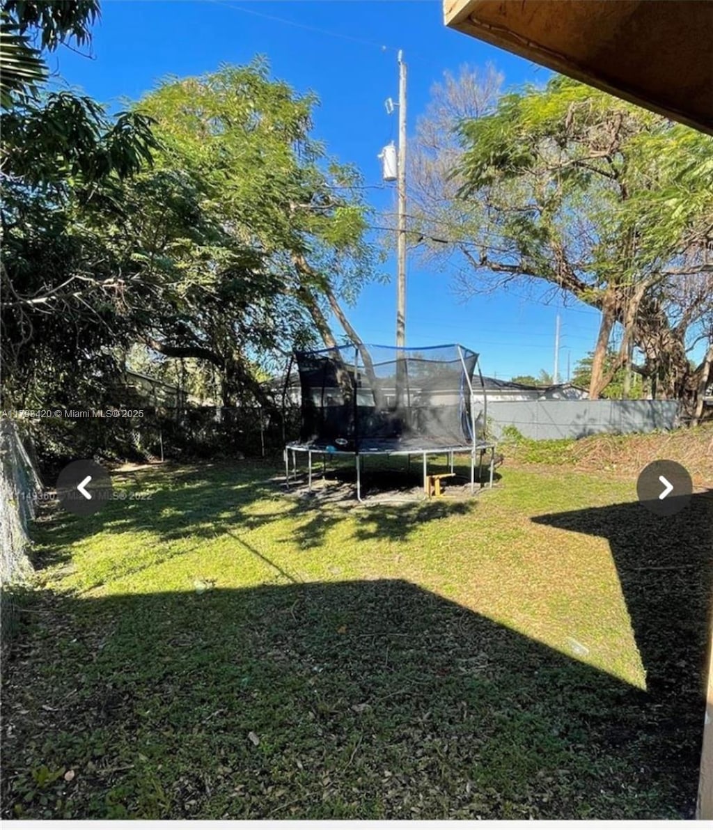 2951 NW 57th St, Miami, FL 33142 - view of yard with a fenced backyard and a trampoline