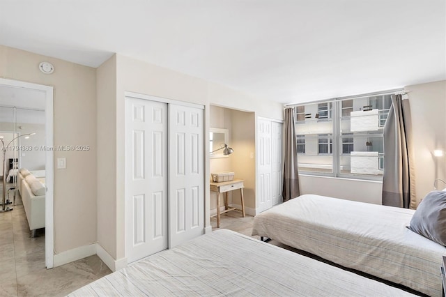 bedroom with baseboards and multiple closets