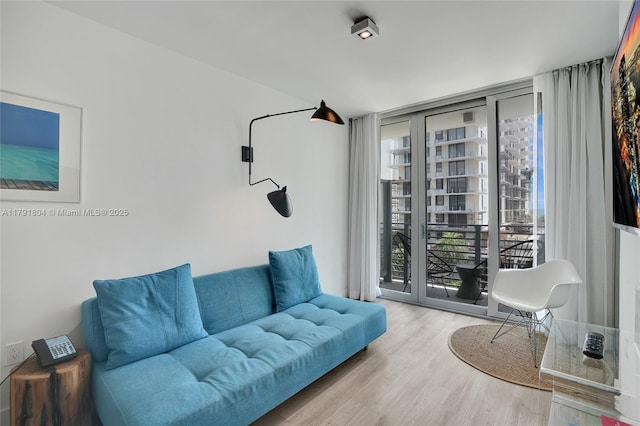 living area with expansive windows and wood finished floors