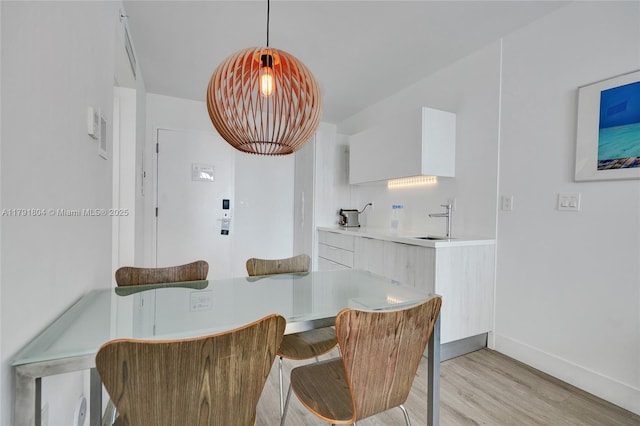 dining room featuring baseboards and light wood-style floors