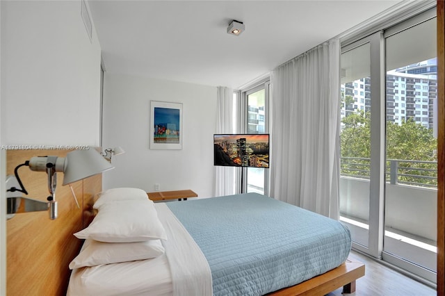bedroom with wood finished floors and access to exterior