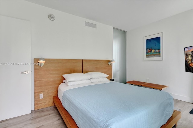 bedroom with visible vents and wood finished floors