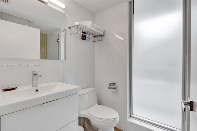 full bath featuring vanity, a stall shower, and toilet