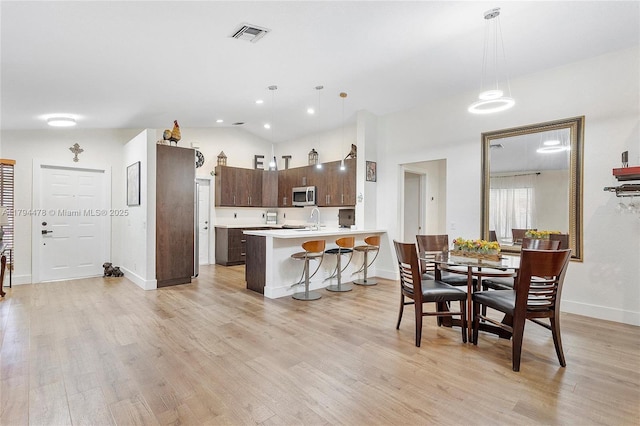 1371 Canary Island Dr, Weston, FL 33327 - dining space with baseboards, vaulted ceiling, light wood-style flooring, and visible vents