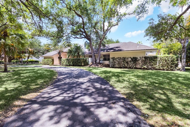 single story home featuring stucco siding, driveway, and a front yard