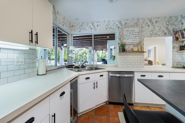 kitchen featuring decorative backsplash, stainless steel dishwasher, a sink, wine cooler, and wallpapered walls