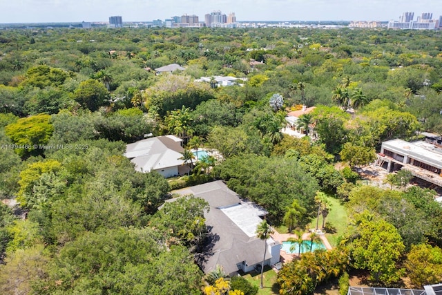 birds eye view of property featuring a city view and a view of trees