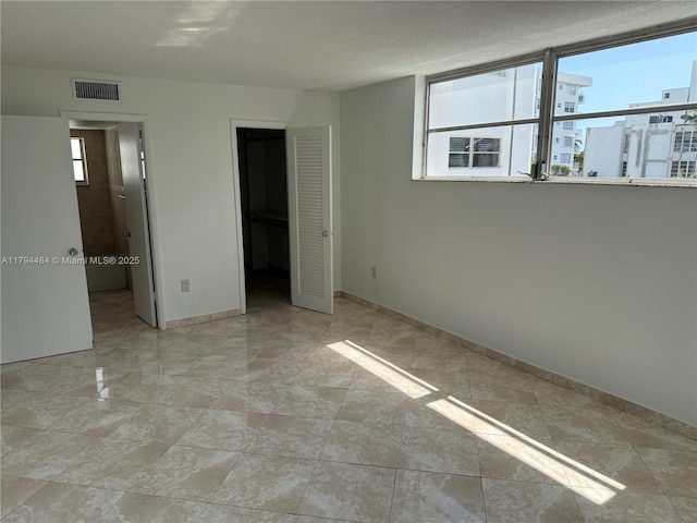 unfurnished bedroom featuring baseboards and visible vents