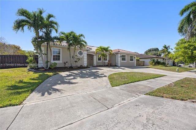 view of front of property featuring fence, a front yard, stucco siding, concrete driveway, and a tile roof