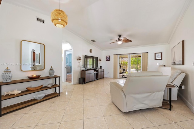 living room featuring crown molding, arched walkways, a ceiling fan, light tile patterned floors, and lofted ceiling