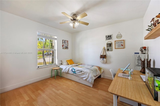 bedroom with baseboards, ceiling fan, and wood finished floors