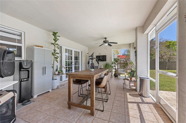 sunroom / solarium with french doors, a ceiling fan, and outdoor dining space